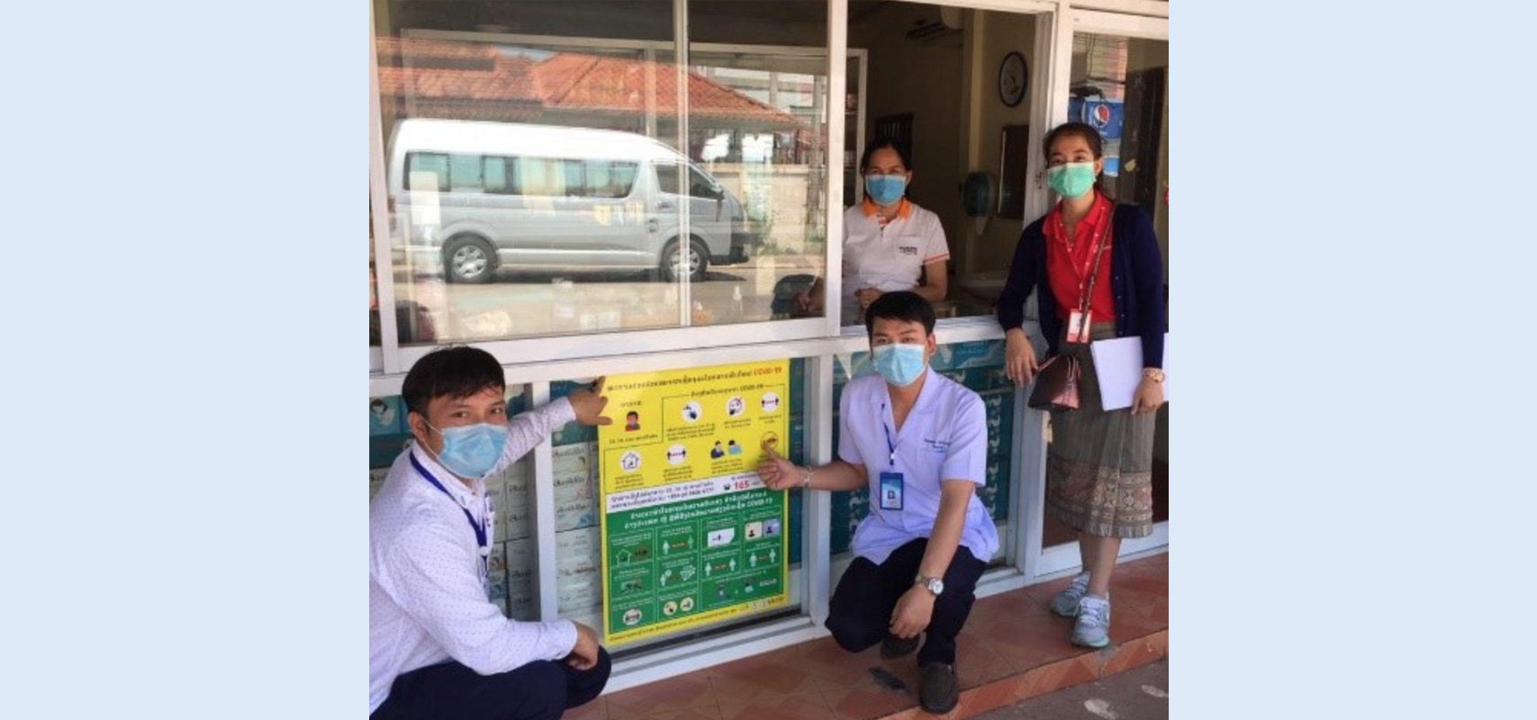 Samkham Meunsy, far right, and MOH workers deliver COVID-19 information to a pharmacy in Vientiane. (Photo: Sisavath Soukkhasing/Save the Children)