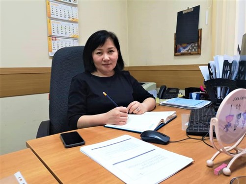 Photo of Gulnaz Azhymambetova seated at desk